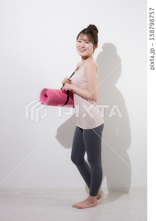 白背景でヨガマットを持つ女性の健康的で美しいスポーツでトレーニングするジムやライフスタイル 138798757
