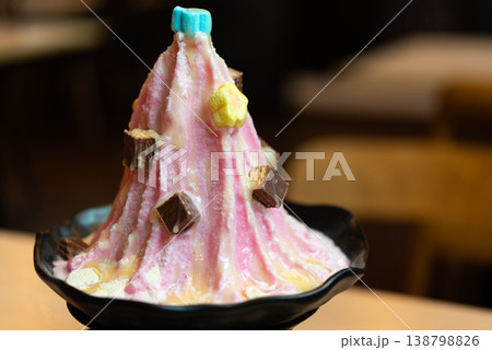 Pink shaved ice dessert topped with chocolate pieces sweet syrup and creamy sauce colorful icy treat served in bowl perfect for cafe menu and summer refreshment Pink shaved ice dessert topped with chocolate pieces sweet syrup and creamy sauce colorful icy treat served in bowl perfect for cafe menu and summer refreshment 138798826