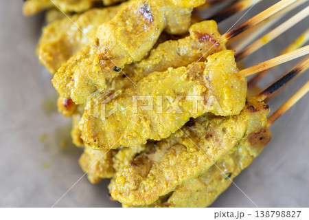 Closeup of grilled pork satay skewers with golden turmeric marinade rich texture and juicy meat perfect for street food and asian cuisine concepts Closeup of grilled pork satay skewers with golden turmeric marinade rich texture and juicy meat perfect for street food and asian cuisine concepts 138798827