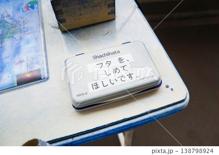 スタンプ台に置いてあるインクの蓋にテープが貼ってある 138798924