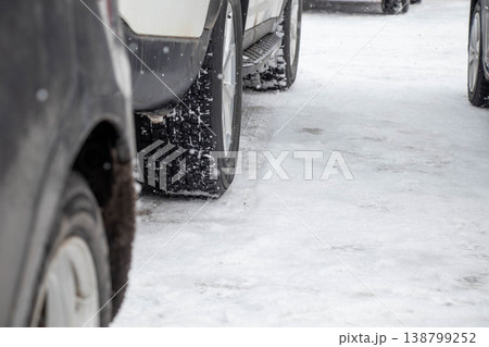 雪道を走行する車とスタッドレスタイヤのクローズアップ(冬の交通・安全イメージ) 雪道を走行する車とスタッドレスタイヤのクローズアップ(冬の交通・安全イメージ) 138799252