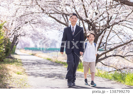 桜の咲く道を登校する小学生と制服の男子 138799270