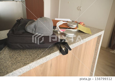 Student backpack, baseball cap, headphones, school supplies on counter Student backpack, baseball cap, headphones, school supplies on counter 138799312
