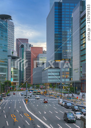 Osaka, Japan - Sep 25 2024, panoramic view of a wide street with cars and buses, trees are planted along road, people walk along sidewalks, a mall in background, at evening, Osaka, Japan Osaka, Japan - Sep 25 2024, panoramic view of a wide street with cars and buses, trees are planted along road, people walk along sidewalks, a mall in background, at evening, Osaka, Japan 138799383