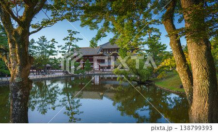 Nara, Japan - Sep 26 2024, Panoramic view across the pond and trees to the facade of Todaiji Temple, Great Buddha Hall, with a blue cloudy sky, Nara, Japan 138799393