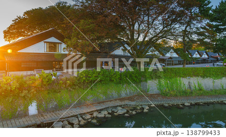 Sakata, Yamagata, japan - Oct 5 2024, Panoramic view from water of Sankyo Soko Storehouse with an alley of trees nearby, at sunset, without people, Sakata, Japan Sakata, Yamagata, japan - Oct 5 2024, Panoramic view from water of Sankyo Soko Storehouse with an alley of trees nearby, at sunset, without people, Sakata, Japan 138799433