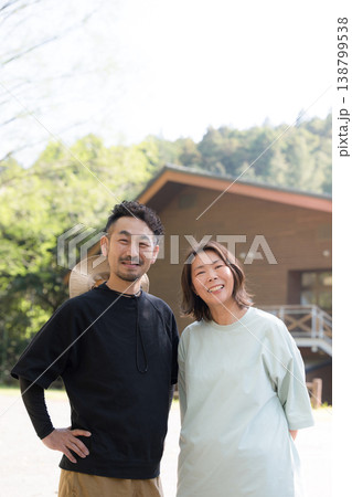 笑顔の夫婦が別荘やキャンプやアウトドア、地方移住などのイメージでカメラ目線で笑顔 笑顔の夫婦が別荘やキャンプやアウトドア、地方移住などのイメージでカメラ目線で笑顔 138799538