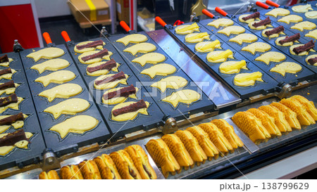 Tokyo, Japan - Oct 14 2024, close-up view of wide cast-iron frying pan with molds used to fry traditional Japanese fish-shaped treats called taiyaki at Tokyo street cafe, without people, Tokyo, Japan 138799629