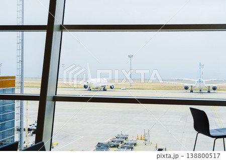 View of airport runway with planes parked and preparing for takeoff during cloudy weather 138800517