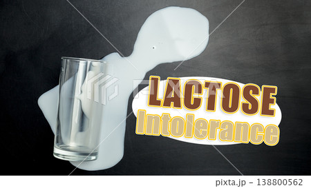 Lactose free milk spilled from glass on black surface with focus on lactose intolerance Lactose free milk spilled from glass on black surface with focus on lactose intolerance 138800562