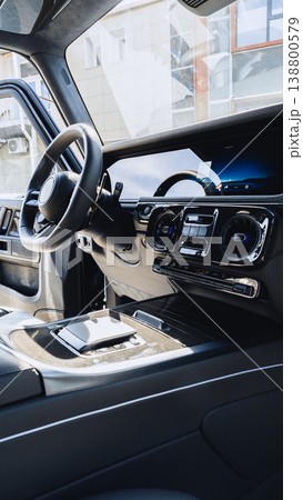 Interior view of a modern car dashboard with controls and steering wheel shown in detail 138800579