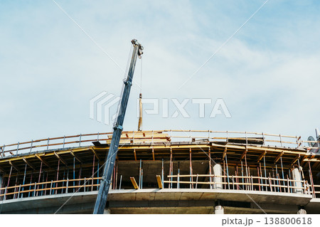 Construction workers using a crane at a building site during daytime in the city 138800618