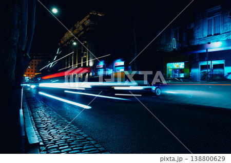 City street at night with moving cars and neon lights near storefronts City street at night with moving cars and neon lights near storefronts 138800629