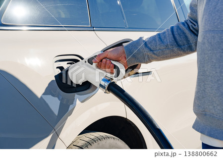 Charging an electric car at a charging station in bright daylight Charging an electric car at a charging station in bright daylight 138800662