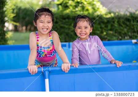 happy preschool child girl playing together with her sister in outdoor portable swimming pool in backyard 138800723