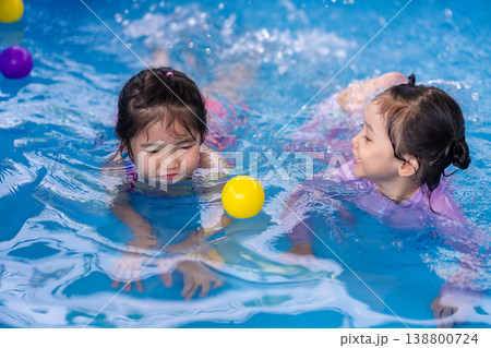 happy preschool child girl playing together with her sister in outdoor portable swimming pool in backyard happy preschool child girl playing together with her sister in outdoor portable swimming pool in backyard 138800724