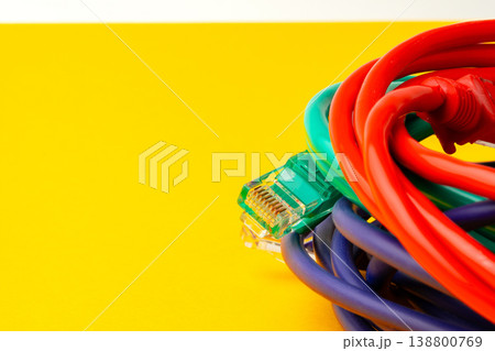 Colorful cables arranged on a yellow background with one connector visible on the side Colorful cables arranged on a yellow background with one connector visible on the side 138800769