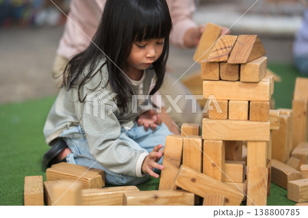 mother and preschool child girl playing with wooden toy block at outdoor 138800785