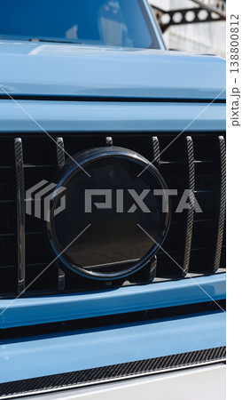 Close view of car grill showing round emblem in bright blue color under sun Close view of car grill showing round emblem in bright blue color under sun 138800812