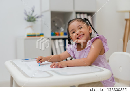 happy preschool child girl drawing and painting with colorful oil pastels on paper happy preschool child girl drawing and painting with colorful oil pastels on paper 138800825
