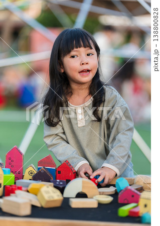 preschool child girl playing with wooden toy block at outdoor 138800828