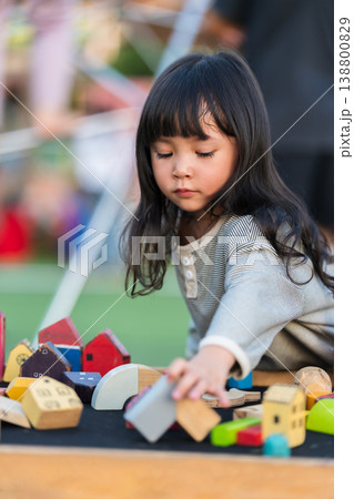 preschool child girl playing with wooden toy block at outdoor 138800829