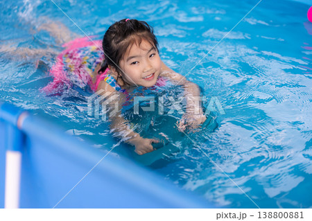 preschool child girl playing in swimming pool in backyard preschool child girl playing in swimming pool in backyard 138800881