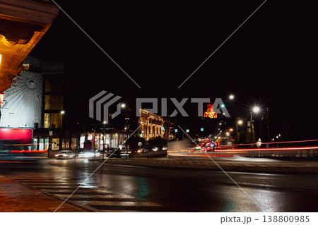 City street at night with moving cars and bright buildings in the background 138800985