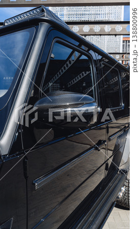 Close view of a black luxury vehicle parked in an urban area during daylight 138800996