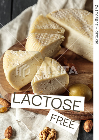 Lactose free cheese on a wooden board with nuts and olives in a kitchen setting Lactose free cheese on a wooden board with nuts and olives in a kitchen setting 138801142