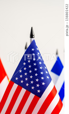 Small American flag stands among other flags on a table in a bright room Small American flag stands among other flags on a table in a bright room 138801422