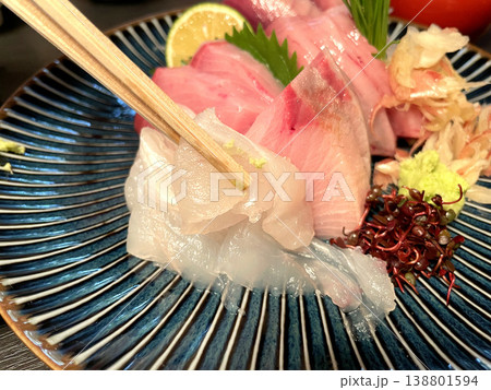 箸でヒラメの刺身をつまむ　刺身盛り合わせ 138801594