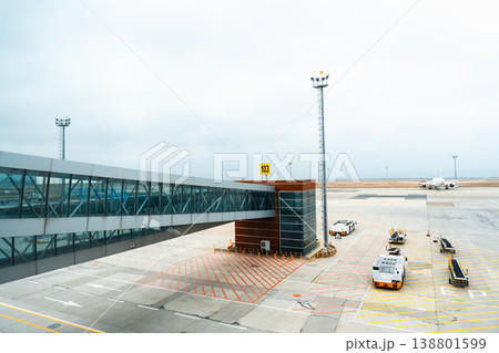 View of airport terminal at gate 103 with planes and vehicles on the tarmac 138801599