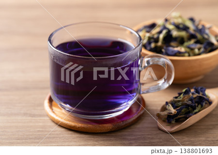 Hot butterfly pea tea in glass cup with dried flowers on wooden background, Healthy herbal drink Hot butterfly pea tea in glass cup with dried flowers on wooden background, Healthy herbal drink 138801693