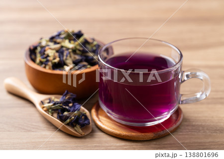 Hot butterfly pea tea in glass cup with dried flowers on wooden background, Healthy herbal drink Hot butterfly pea tea in glass cup with dried flowers on wooden background, Healthy herbal drink 138801696