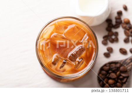 Iced latte coffee in a glass with roasted coffee beans. Popular refreshing summer drink Iced latte coffee in a glass with roasted coffee beans. Popular refreshing summer drink 138801711