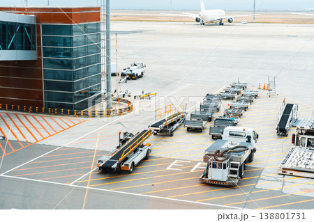 Airport ground services prepare luggage for an arriving flight at a busy terminal Airport ground services prepare luggage for an arriving flight at a busy terminal 138801731