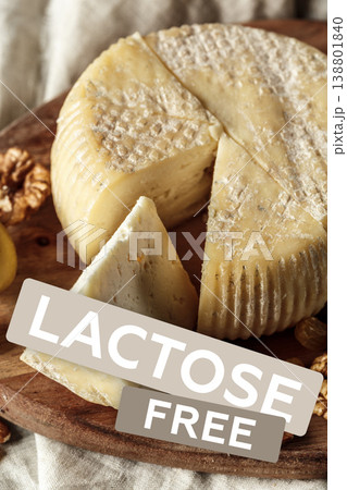 Lactose free cheese displayed on a wooden board with nuts and lemon slices 138801840