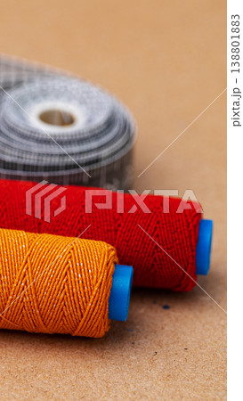 Spools of colorful thread on a flat surface during a crafting session Spools of colorful thread on a flat surface during a crafting session 138801883