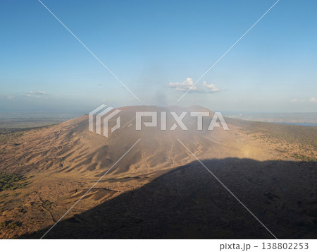 Volcano emits steam near a vast landscape at midday Volcano emits steam near a vast landscape at midday 138802253