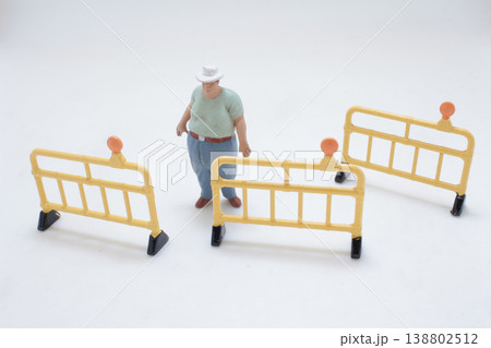 Miniature Figure Surrounded By Safety Barriers 138802512