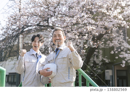 桜の前でガッツポーズする男性作業員のグループ 桜の前でガッツポーズする男性作業員のグループ 138802569