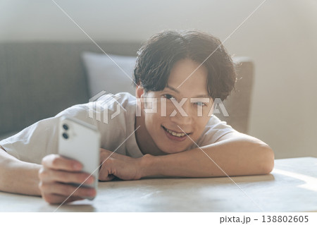 笑顔でスマホを使う男性 138802605