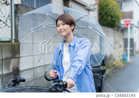 自転車に乗って傘をさす女性・交通違反 自転車に乗って傘をさす女性・交通違反 138803193