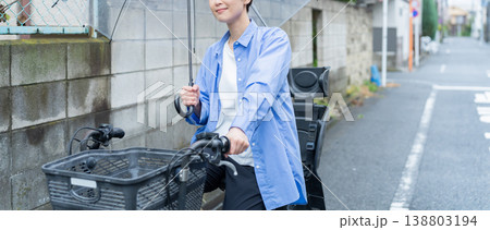 自転車に乗って傘をさす女性・交通違反 自転車に乗って傘をさす女性・交通違反 138803194