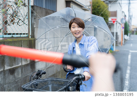 自転車に乗って傘をさす女性・交通違反 138803195