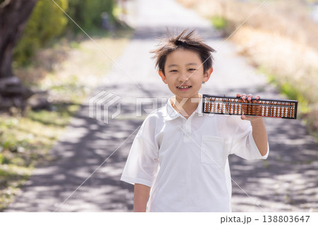 笑顔でそろばんを持つ小学生の男の子 138803647