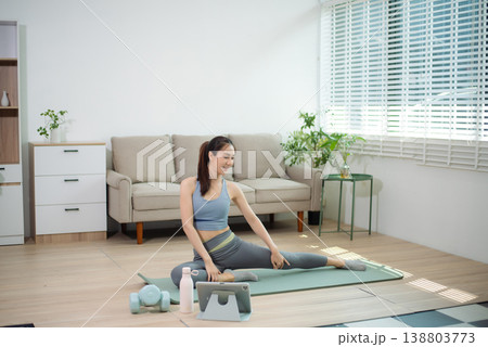 Asian woman exercising with dumbbells at home. Home workout, fitness training, strength exercise, healthy lifestyle, yoga mat, indoor sport, wellness and active living. Asian woman exercising with dumbbells at home. Home workout, fitness training, strength exercise, healthy lifestyle, yoga mat, indoor sport, wellness and active living. 138803773