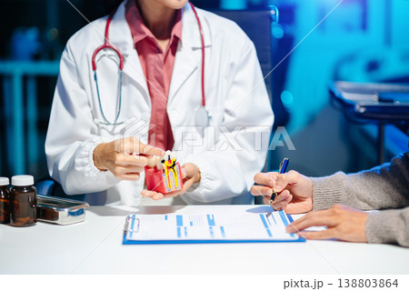 Asian female dentist explains dental model and treatment form to patient during consultation Asian female dentist explains dental model and treatment form to patient during consultation 138803864