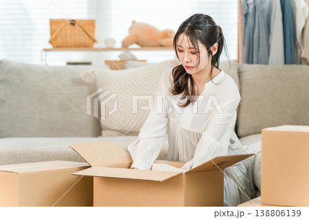 家で引越しの荷造り,不用品整理,レンタル,サブスク,ネットショッピング,フリマアプリをする若い女性 138806139